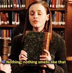humorous GIF of girl smelling a book